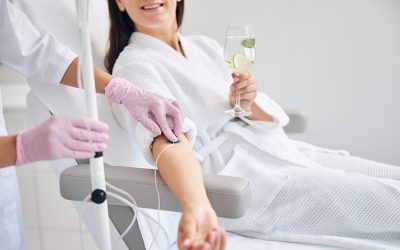 Cropped photo of a woman with a glass of drink sitting in a cosmetic chair